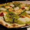 Pizza de bacalao y langostinos con base de salsa verde